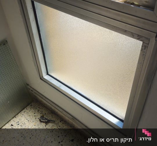 חלון עם כלים על הרצפה לידו